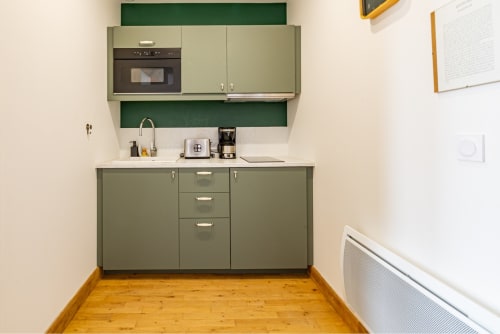 Petite cuisine verte de l'appartement Logis Edith à La Maison George, Flavigny sur Ozerain, avec évier, cuisinière et parquet