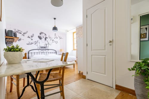 Appartement Logis Edith à La Maison George avec table à manger, cuisine, chambre à coucher décorée d'une fresque murale et parquet en bois
