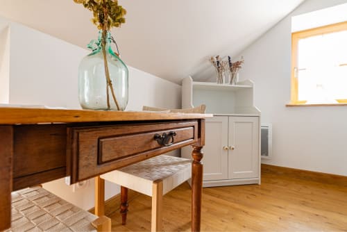 Logis Olympe apartment at La Maison George features wooden desk with dried flowers, white storage cabinet, and hardwood