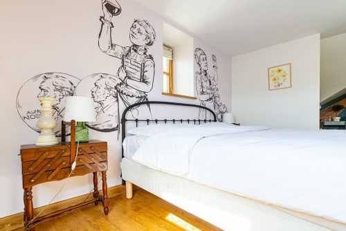 Logis Marie bedroom at La Maison George in Flavigny sur Ozerain with metal bed, wooden nightstand, and vintage wall murals