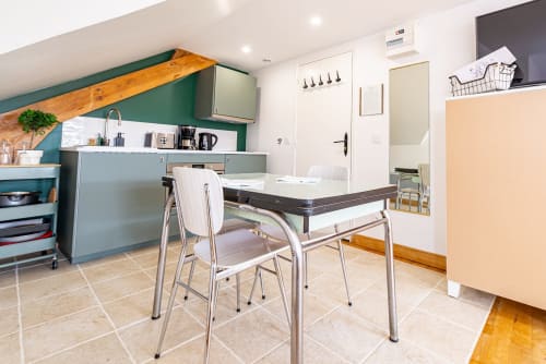 Modern kitchen and dining area in Logis Marie apartment at La Maison George, Burgundy, with teal cabinetry and dining table