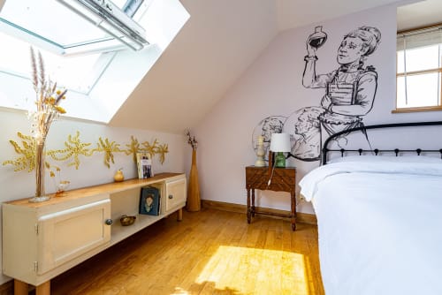 Attic bedroom at La Maison George in Flavigny with skylights, wooden floors, vintage bed, and decorative wall art.