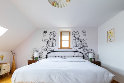 Cozy bedroom at La Maison George with metal bed frame, sketch wall art, and natural light from wooden-framed window