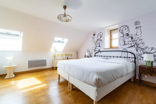 Chambre mansardée lumineuse à La Maison George avec lit queen-size, puits de lumière, parquet et fresques murales artistiques à Flavigny-sur