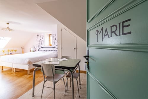 Logis Marie apartment at La Maison George, Flavigny-sur-Ozerain, with green door, dining area, and bedroom.