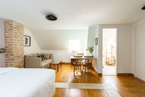 Appartement Logis Joséphine à La Maison George : chambre spacieuse avec cheminée en briques, coin repas et parquet