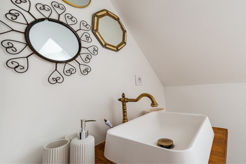 Élégante vasque de salle de bain dans l'appartement Logis Joséphine à La Maison George avec lavabo blanc, robinetterie en laiton et décoration