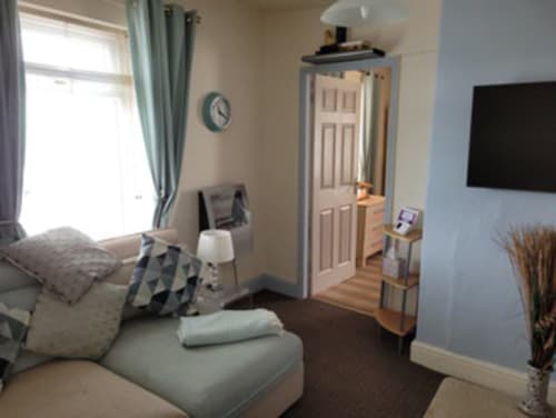 Modern 1-bedroom apartment at Jane's B&B in Guisborough with bed, sitting area, flat-screen TV, and bright window