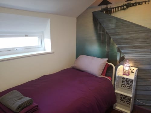 Cozy bedroom with burgundy bedding, purple pillow, and mural of wooden pier at Jane's B&B villa in Guisborough