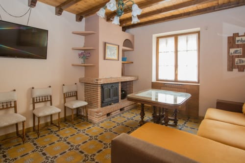Amplio salón en apartamento de Ávila con chimenea, vigas de madera, comedor y decoración tradicional