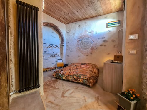 Camera rustica a CasaRosada wellness B&B a Vidracco con terrazza giardino, radiatore e finestra ad arco tradizionale.