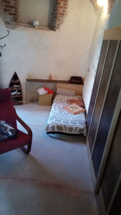 Camera accogliente a CasaRosada wellness B&B a Vidracco con letto singolo, scrivania in legno e dettagli in mattone