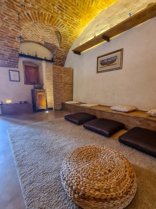 Camera romantica a CasaRosada a Vidracco con soffitto in laterizio arcuato, cuscini da pavimento e arredamento rustico italiano
