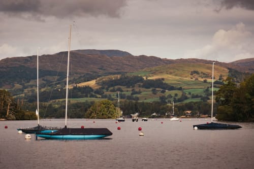 Sailboats moored on calm water with rolling hills and countryside near Guisborough, England