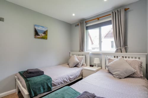 Cornish Holiday - 91 Hengar Manor. Twin bedroom with single beds, bedside cabinet, lamp, clock throws and complimentary towels.