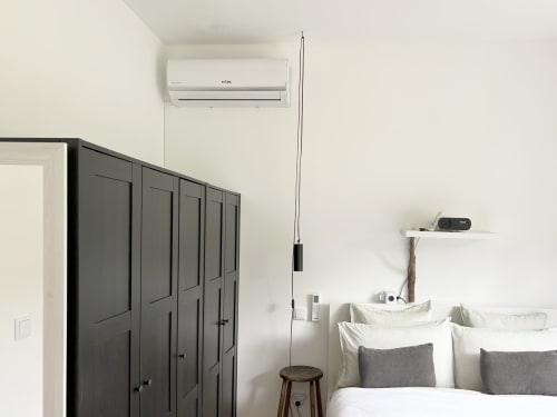 Modern bedroom at Villa Várzea with air conditioning unit, dark wardrobe, white bedding, and wooden stool in Várzea,
