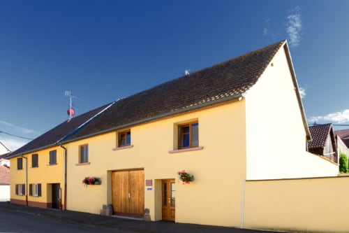 Gîte La Grange B&B à Neuf-Brisach, maison jaune avec toit marron et portes en bois