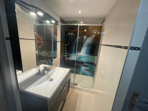 Salle de bain moderne au Gîte du Miroir à Domérat avec douche vitrée et carrelage mural motif cascade