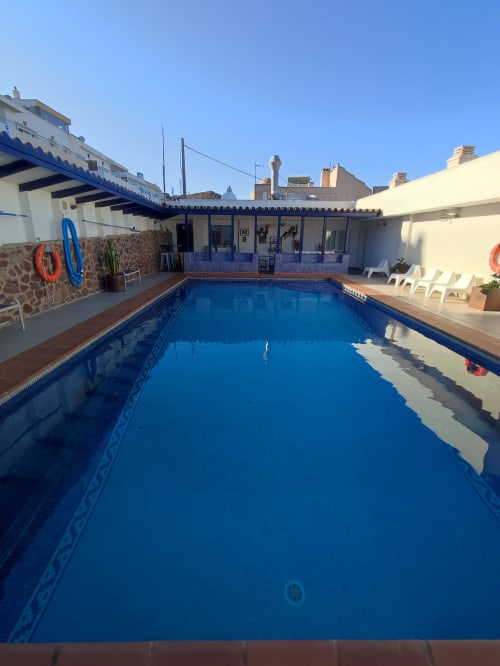 Piscina del hotel El Faro De Los Genoveses en San José, Almería con tumbonas y vistas al mar
