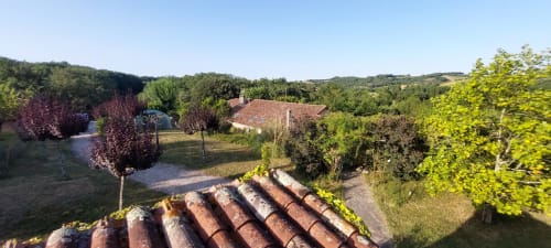 Rustic countryside view of Les Gites de Campardon in Montois, France, with terracotta roof tiles and lush gardens