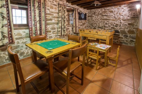 Sala de entretenimiento con billar y futbolín en casa rural de piedra rústica, Ávila España