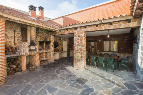 Patio rústico de piedra con chimenea en casa rural Apartamentos Turísticos Ávila en España