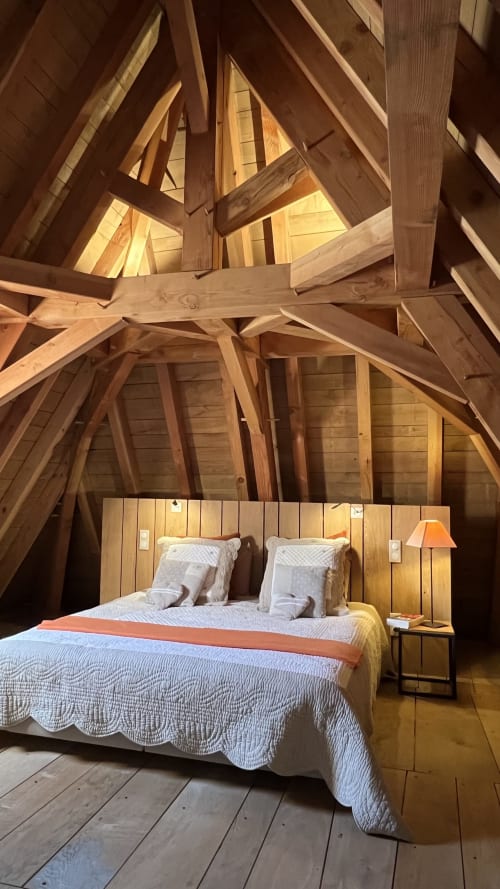 Chambre mansardée rustique au Lapin sur le Toit avec poutres apparentes, lit queen-size et éclairage chaleureux à Rouffignac