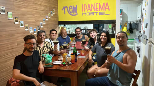 Grupo de hóspedes socializando com bebidas na New Ipanema Hostel no Rio de Janeiro