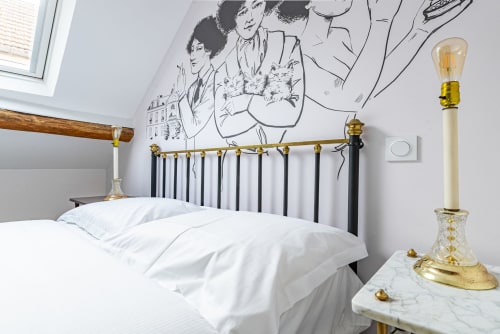 Elegant bedroom at La Maison George in Flavigny sur Ozerain with brass bed frame, white bedding, and vintage wall mural