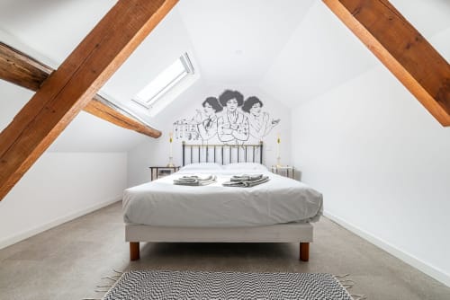 Chambre mansardée à La Maison George avec poutres apparentes, lit en fer forgé, lucarne et décoration murale à Flavigny-sur-Ozerain