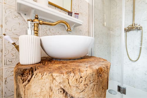 Luxurious bathroom sink at La Maison George, Logis George apartment with white bowl sink on cork base and brass faucet