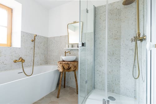 Modern bathroom at La Maison George with freestanding bathtub, walk-in shower, and wooden vanity