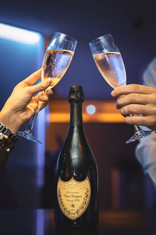 Deux coupes de champagne Dom Pérignon trinquant à Le Gîte du Miroir Domérat, célébration élégante