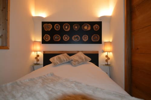 Chambre chaleureuse à la Résidence Le Pacha avec lit, éclairage doux, éléments de décor en bois et art mural décoratif