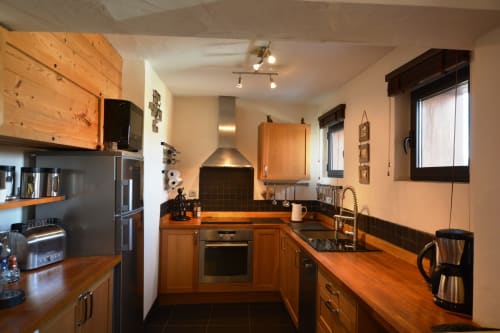 Cuisine moderne à la Résidence Le Pacha à Courchevel, avec mobilier en bois, électroménagers inox et finitions sombres