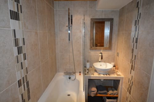 Salle de bains moderne à la Résidence Le Pacha, Courchevel avec murs carrelés, lavabo rond, baignoire et douche vitrée