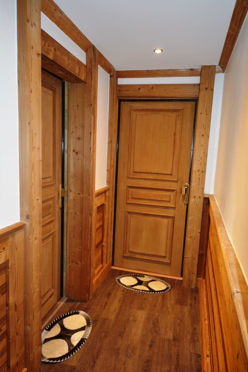 Couloir en bois avec portes à panneaux à la Résidence Le Pacha, appartement de luxe à Courchevel