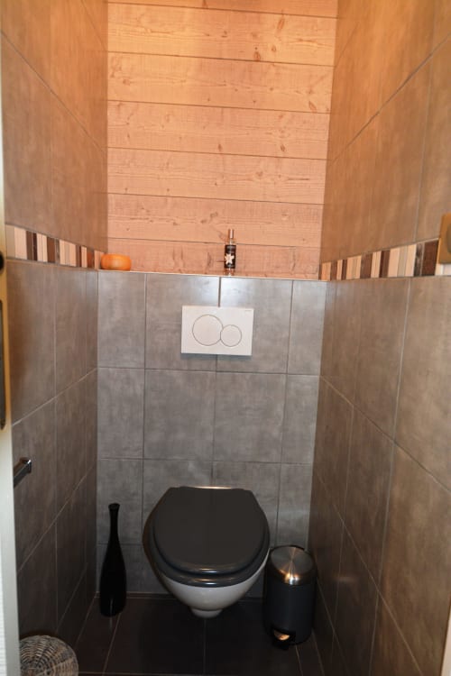 Toilettes modernes dans un appartement de luxe à la Résidence Le Pacha, Courchevel, avec système de double chasse et détails en bois