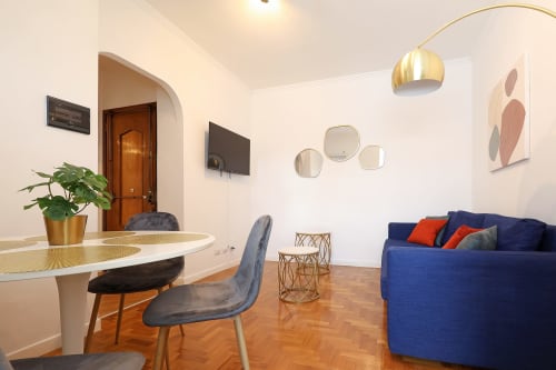 Moderna zona living dell'hotel Re di Roma a Roma con divano blu, tavolo rotondo e arredamento contemporaneo