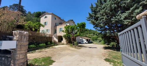 Le Mas de Trépeloup, gîte rural en Alès avec bâtisse en terre cuite, portail fermé et allées plantées d'arbres