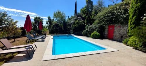 Piscine du Mas de Trépeloup à Alès avec transats, parasols et verdure luxuriante