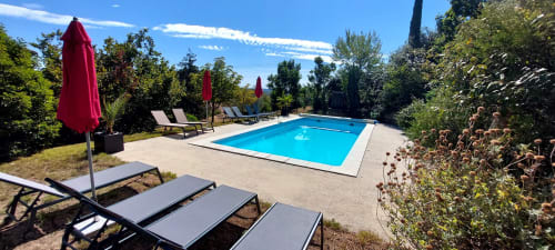 Piscine rectangulaire avec transats et parasols rouges au Mas de Trépeloup B&B à Alès, France