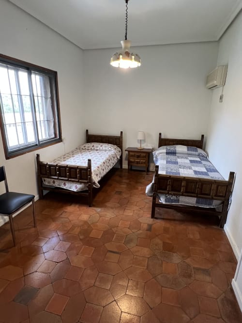 Dormitorio amplio con dos camas de madera, suelo de baldosas de terracota en Villa Luxury cerca del Puy du Fou en Argés