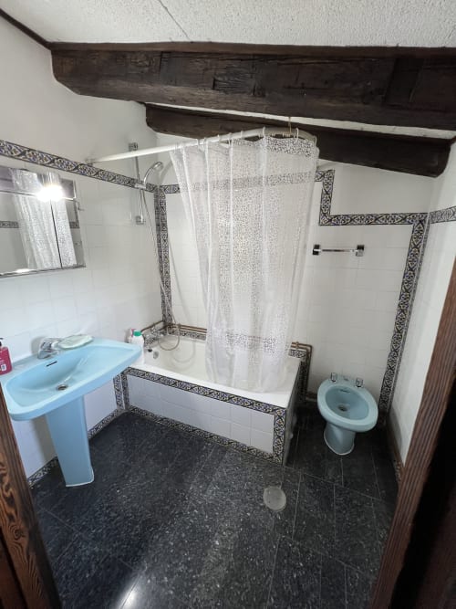 Bathroom at Luxury Villa near Puy du Fou with shower, bathtub, blue sink, and decorative tile accents