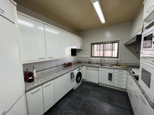 Cocina moderna equipada con armarios blancos, encimeras de granito, lavadora y en Villa Luxury cerca del Puy Du Fou, Arges, Toledo, España.