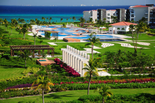 Resort Mareazul frente al mar en Playa del Carmen con piscinas oceanfront, palmeras y jardines coloridos con vistas al turquesa
