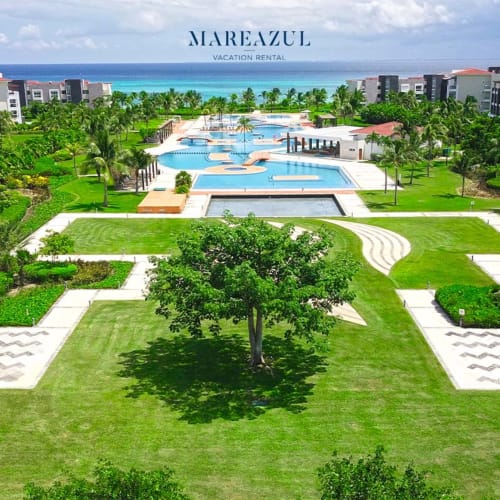 Resort frente al mar Mareazul en Playa del Carmen con piscinas, jardines cuidados, palmeras y Mar Caribe turquesa