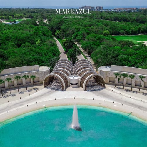 Piscina turquesa del Resort Mareazul frente al mar con diseño arquitectónico único, jardines exuberantes y vistas al horizonte de Playa del Carmen