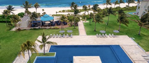 Piscina y playa del Resort Mareazul frente al mar en Playa del Carmen con tumbonas y vista al océano