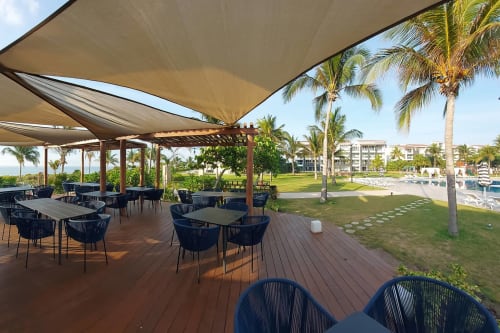 Terraza frente al mar en Mareazul Resort Playa del Carmen con áreas sombreadas, palmeras y vistas al océano